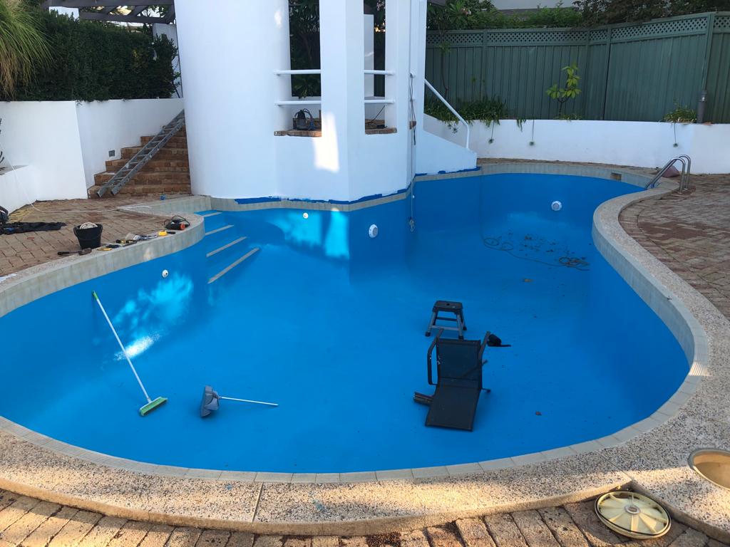 Empty swimming pool freshly coated in bright blue pool paint