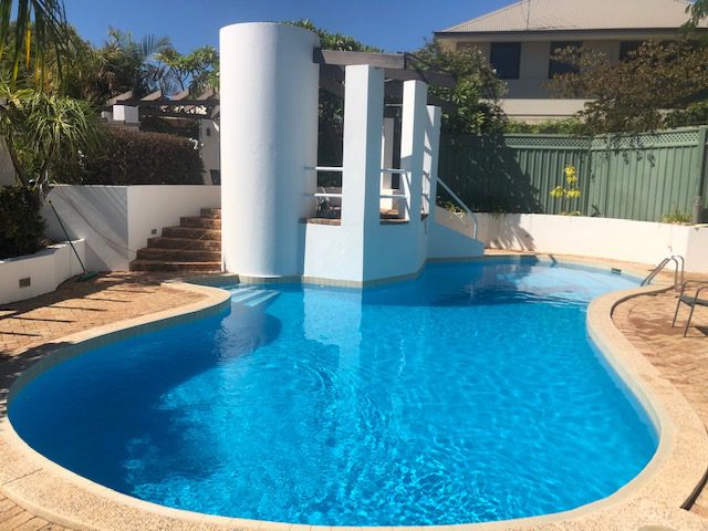 Finished swimming pool filled with clear blue water after repainting